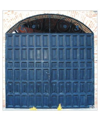 1064 Puerta de diversos cuarterones de chapa y adornos forjados