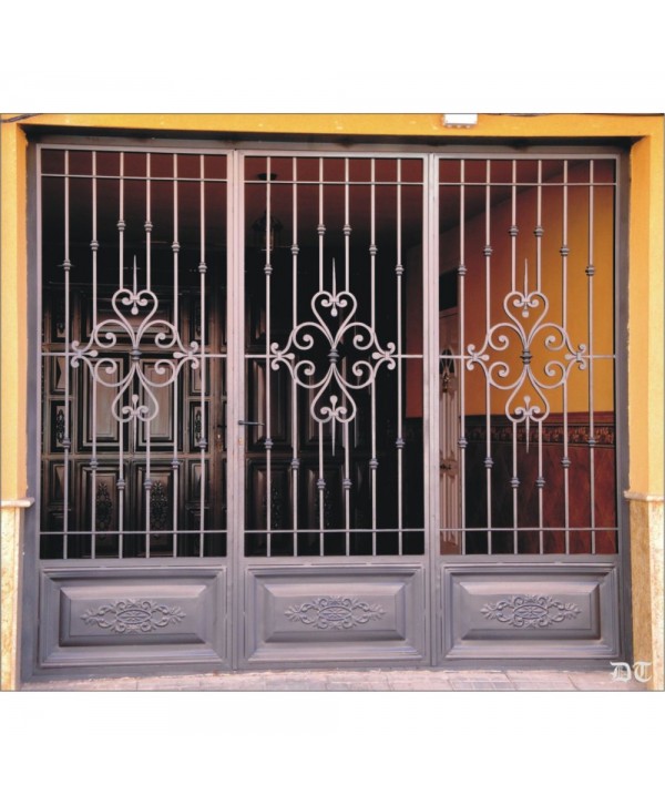 1607 Cancela con cuarterones de chapa con dibujo y adornos